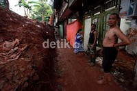 Salah satu rumah yang temboknya jebol ditutupi dengan kain terpal.