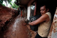 Seorang warga mengevakuasi perabotan rumah tangganya.