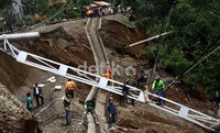 Puluhan pekerja memperbaiki tiang listrik yang patah di lokasi longsor di Cilebut, Kabupaten Bogor. Ramses/detikcom.