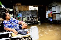 Seorang ibu hanya bisa memandangi rumahnya yang terendam banjir. Ramses/detikcom.