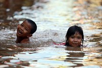 Anak-anak tampak senang bermain banjir.