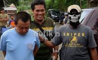 Ruddi Cahyono (kiri) tertunduk saat digiring petugas. Arbi Anugrah/detikcom.