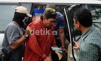 Petugas membawa Yadi Mulyadi alias Buke, Yadi Mulyadi menggunakan pakaian pakaian merah dengan topi tentara. Arbi Anugrah/detikcom.