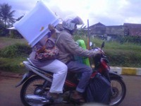     Helm model anti hujan terbaru ini, dipotret di komplek perumahan Grand Depok City. Si Ibu tampaknya habis berbelanja. (Foto: Brainerd Daniel T)