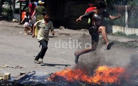 Anak-anak tampak bermain di sela-sela demo warga.
