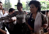     Hartati berjalan menuju ruang tunggu terdakwa.