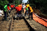 Para pekerja melakukan pengepresan rel kereta yang sempat bergeser akibat longsor. Ramses/detikcom.