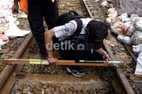 Petugas PT KAI mengukur rel kereta api yang sempat bergeser akibat longsor. Ramses/detikcom.