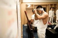 Taeyang tampak memasang scarf-nya untuk melengkapi gayanya. (dok. YG Entertainment)