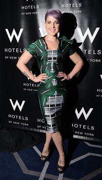 Kelly tampil dengan dress futuristiknya yang bernuansa hijau abu-abu. (Andrew H. Walker/Getty Images).