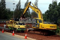 Sebuah truk hilir mudik mengangkut tanah dari lokasi pelebaran jalan.