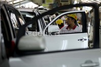 Beberapa pekerja menyelesaikan pekerjaan eksterior mobil.