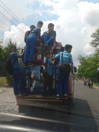 Para pelajar ini berhasil naik di atas angkot sambil berpose. (Foto: Santoso)
