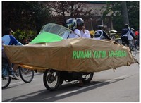     Bodi kapal ini terbuat sangat rapi dengan kertas coklat, bambu, serta hiasan pelastik bening dan kertas hijau yang bertuliskan Rumah Yatim Ar-Ridho terlihat mencolok.  (Foto: Ardinansah Rasid).