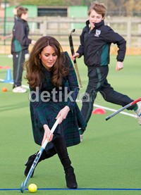 Dengan mengenakan dress bermotif kotak-kotak, Kate memamerkan kemampuannya bermain hoki. (Getty Images/WPA Pool)
