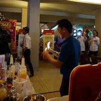 Sambil yang lain menari Gangnam Style, bartender melakukan aksi melempar-lempar botol dan menyemburkan api.