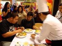 Berani ikut lomba makan kari pedas? Kedua pria berbaju hitam ini bersaing untuk mendapatkan voucher Curryvora senilai Rp 100.000 dan Rp 75.000. Tampak Chef Elman sedang menambahkan sambal ke dalam kari agar semakin pedas rasanya.