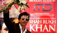 SRK menerima bunga saat jumpa pers.
