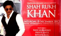 SRK tampak memakai kemeja putih dan vest berwarna hitam.