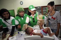 Ketua umum Yapnas, Ike Nirwan Bakrie menimbang langsung berat badan seorang bayi dengan didampingi orang tuanya dan kedua perawat yang memeriksa. Yayasan Penyantun Anak Asma Indonesia (Yapnas) dan Yayasan ANTV Peduli untuk negeri kembali menggelar acara bakti sosial untuk 1000 kaum dhuafa di Cilincing, Jakarta Utara.     