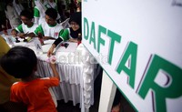     Seorang anak kecil datang menuju meja pendaftaran untuk ikut memeriksakan diri dengan didampingi orang tuanya.
