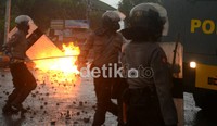 Barikade tameng pihak kepolisian diserang dengan lemparan bom molotov dari arah mahasiswa.