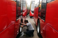 Petugas membersihkan bus TransJakarta di Pool Damri, Pesing, Jakarta Barat.