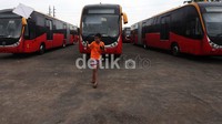 Seorang anak bermain layang-layang di depan bus TransJakarta di Pool Damri, Pesing, Jakarta Barat.