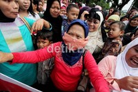 Seorang demonstran menutupi wajahnya dengan BH.