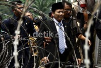 Wakil Ketua DPR Taufik Kurniawan meninggalkan massa seusai dilempari botol air.
