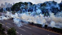 Aparat kepolisian membubarkan massa dengan gas air mata. Ramses/detikFoto.
