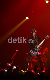 Aksi gitaris Guns N' Roses di atas panggung.