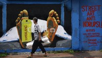 Pejalan kaki melintas disamping  mural yang menggambarkan jenazah kematian koruptor kasus Hambalang.  ramses/detikfoto     