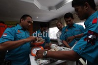 Petugas memeriksa barang bukti yang diamankan dari tersangka.