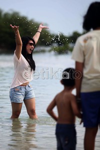 Wisatawan menikmati keindahan Pantai Pasir Perawan di Pulau Pari, Kabupaten Kepulauan Seribu, Jakarta, Minggu (16/12).