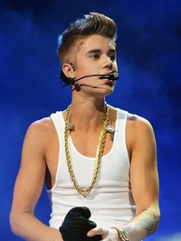 Ia pun membuka kemeja merahnya dan memamerkan bentuk tubuhnya. Michael Kovac/Getty Images for Jingle Ball 2012.