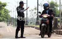 Salah seorang petugas Dishub DKI Jakarta, menghentikan pemotor dan meminta mereka untuk keluar jalur sepeda Banjir Kanal Timur (BKT), Jakarta Timur.