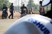Para petugas Dishub DKI Jakarta, terus siaga berjaga mengamankan jalur sepeda Banjir Kanal Timur (BKT), Jakarta Timur, Selasa (19/12), mulai pukul 07.30 WIB sampai pukul 10.00 WIB, dari serobotan para pengendara motor.     