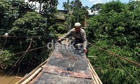 Marhusin HB (45), sedang memperbaiki jembatan Srengseng Sawah.