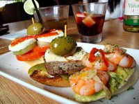 Aneka pinchos atau camilan untuk individu. Dari kiri ke kanan, ada ensalada de verano, montadito de solomillo, dan brocheta de guacamole y gambas al ajillo.