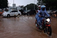 Seorang pengendara motor melintasi jalanan yang banjir di depan Istana Negara.