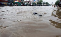 Banjir menyebabkan kemacetan karena hanya satu lajur yang bisa dilalui.