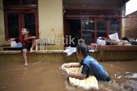 Meskipun rumah mereka terendam air, keceriaan terlihat di wajah anak-anak ini.