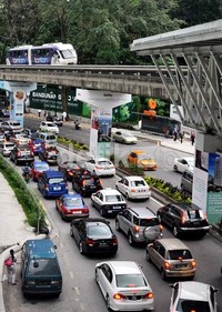 Gerbong kereta KL-Monorail melintasi jembatan monorel di atas jalan Sultan Ismail, yang saat itu dipadati mobil-mobil pribadi sekitar pukul 17.00 waktu Kuala Lumpur.