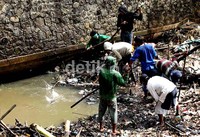 Puluhan petugas dari SDPU Tata Air Jakarta Timur, membersihkan tumpukan sampah rumah tangga yang menyumbat pintu air Kalimalang, Jakarta Timur.