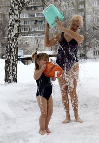 Seorang murid TK bermain air bersama gurunya di tengah salju bersuhu minus 25 derajat celcius. Reuters/Andrei Kasprishin.