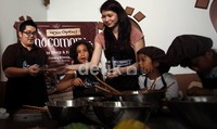Laura asyik bermain dengan cokelat bersama anak-anak kecil.
