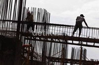 Para pekerja merangkai besi beton yang akan digunakan untuk tiang pancang.