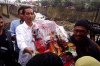 Jokowi memberi parsel kepada petugas pintu air.