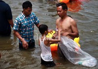 Anak kecil pun turut membantu mengumpulkan sampah di pantai Ancol.